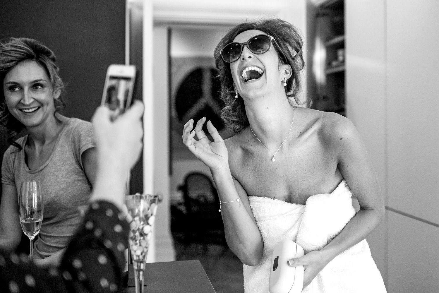 bride in towel laughing with sunglasses on