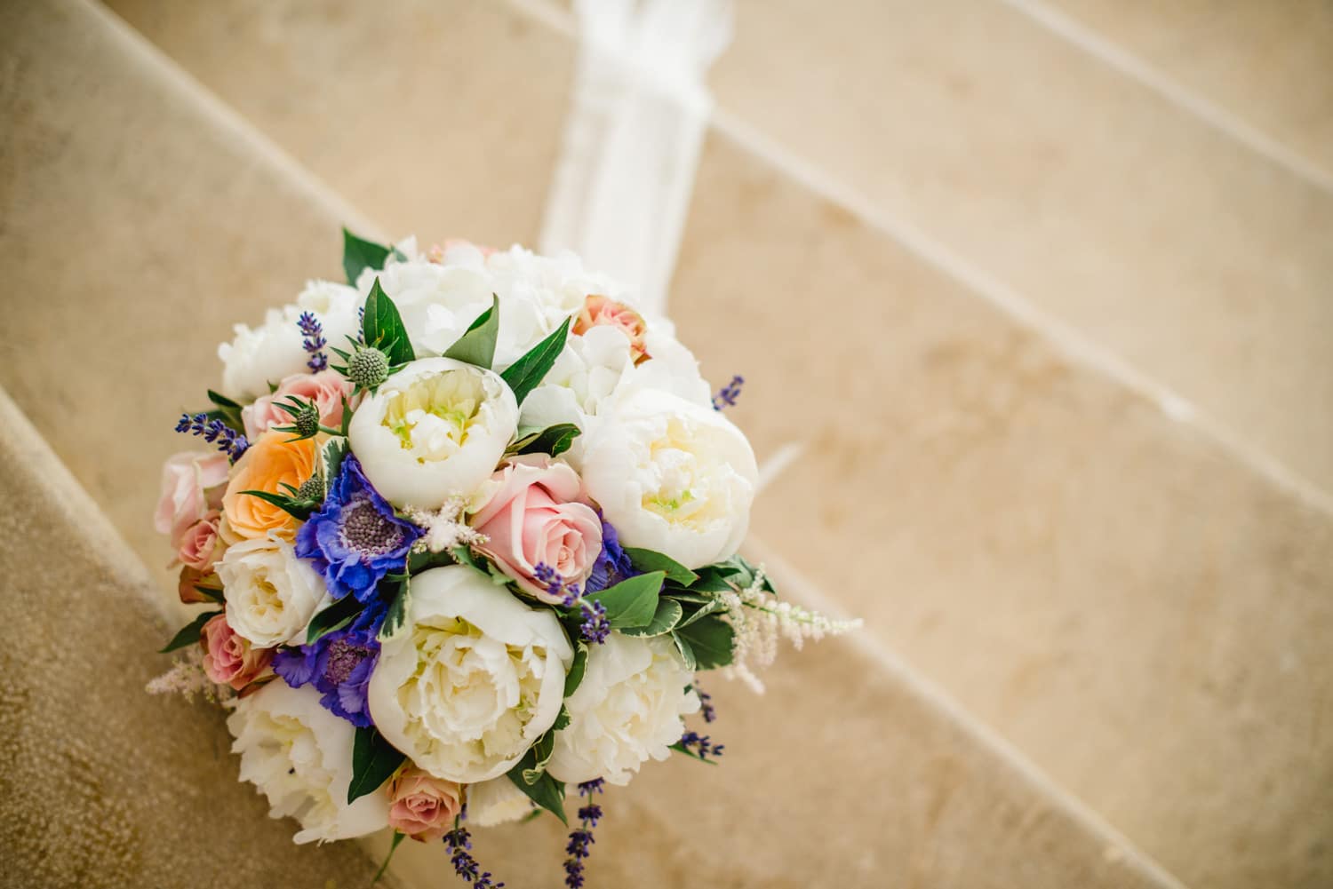 wedding bouquet on steps of Chateau de Lacoste wedding venue