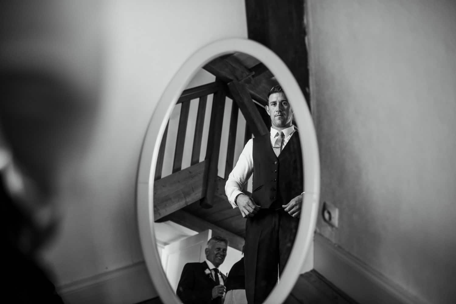 groom in reflection of mirror at Chateau de Lacoste wedding venue