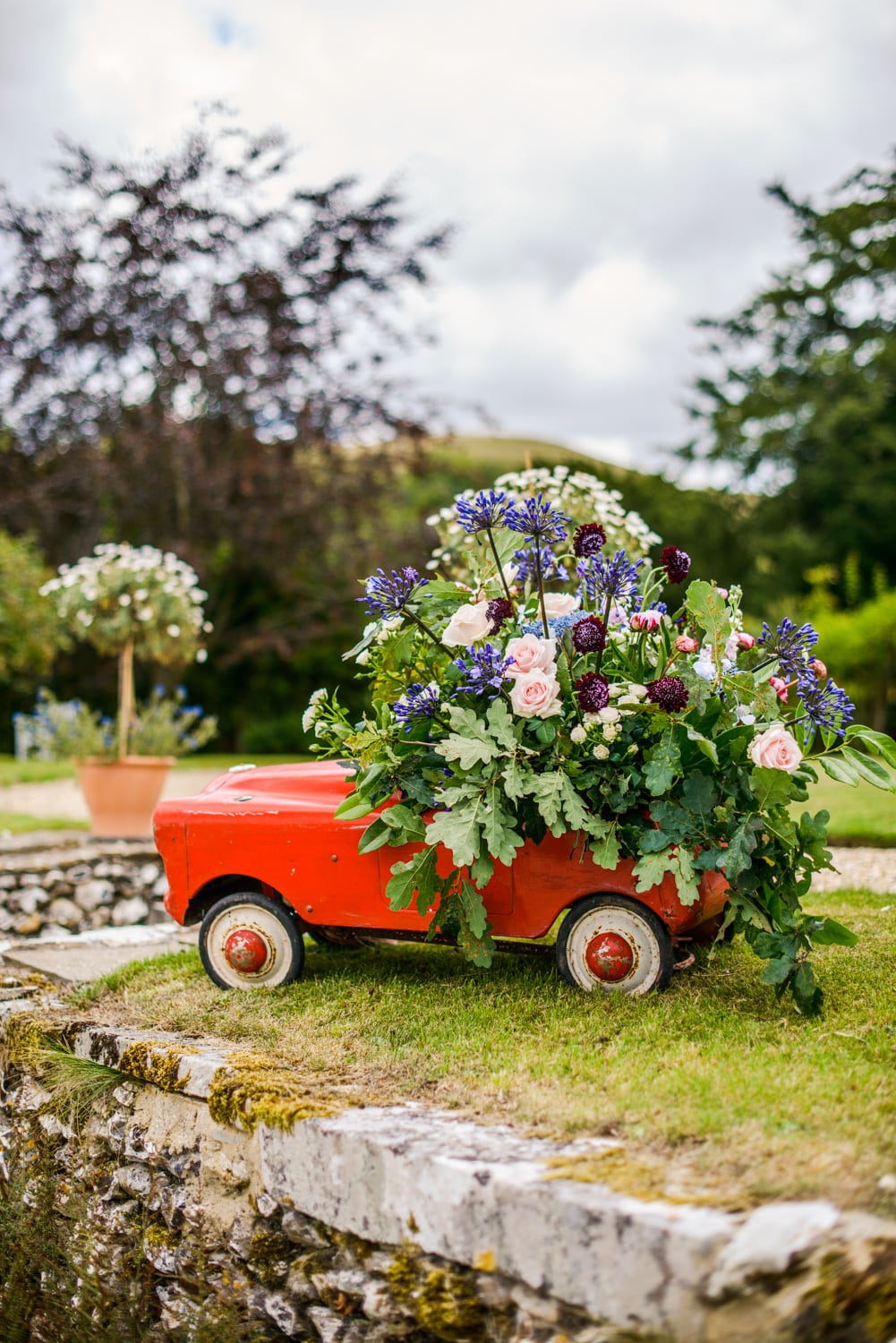 old red tin car with floral display