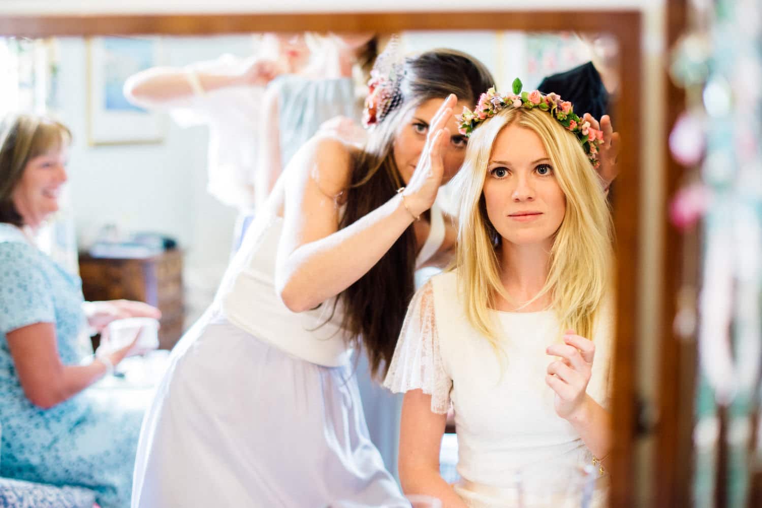 bride looking in mirror with flower crown