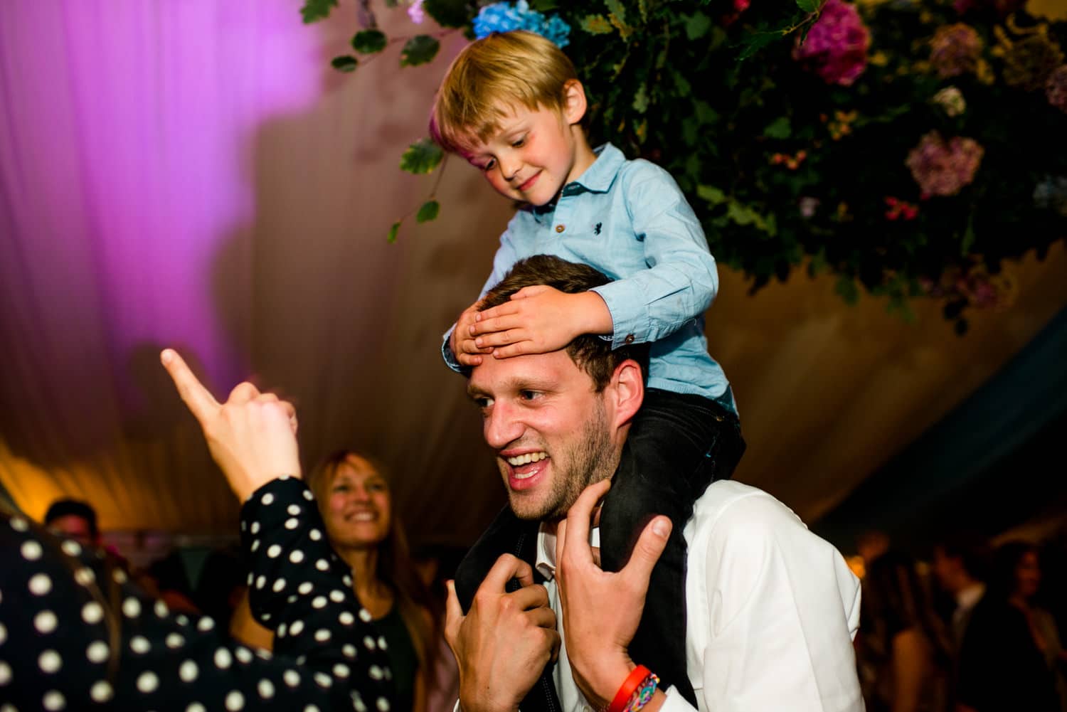 kid on shoulders of groom during wedding party