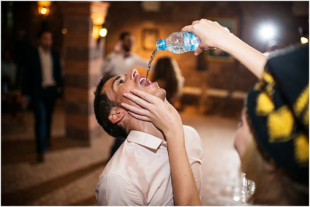 wedding guest with water being poured into mouth