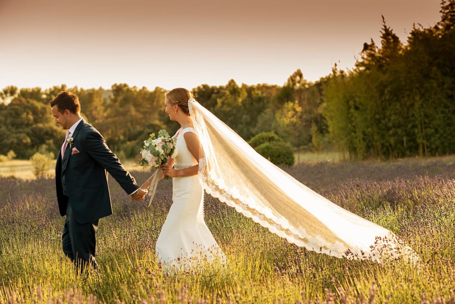 bride and groom walking through lavender in France