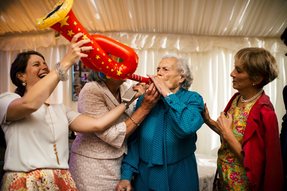 Grandma blowing an inflatable saxophone