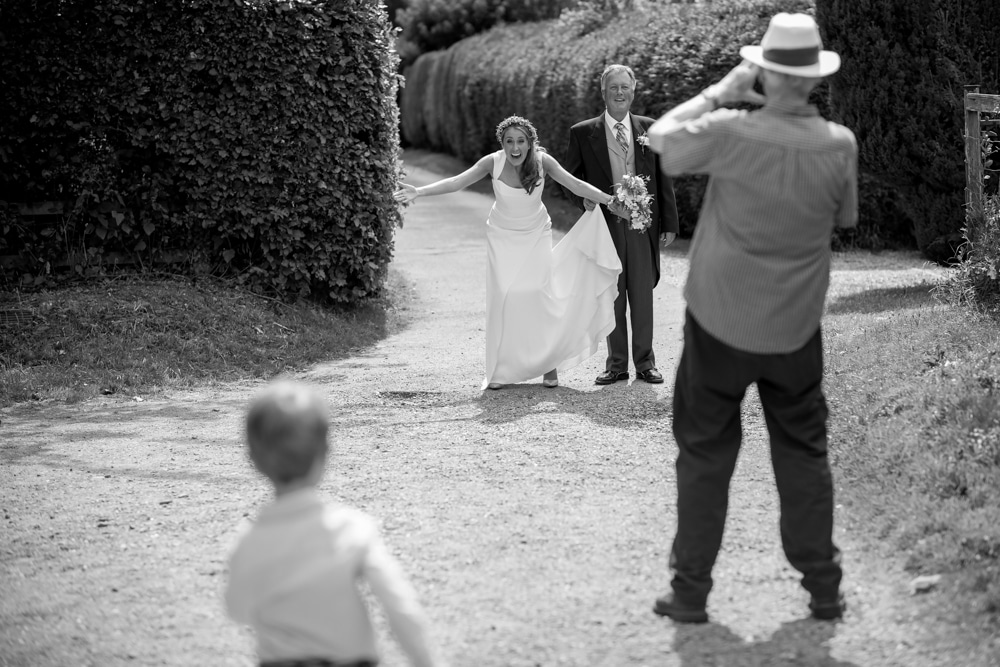 Bride welcoming page boy with open arms