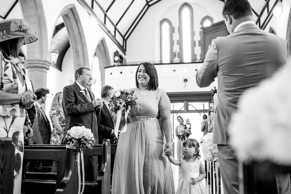 bridesmaid walking down aisle with flower girl