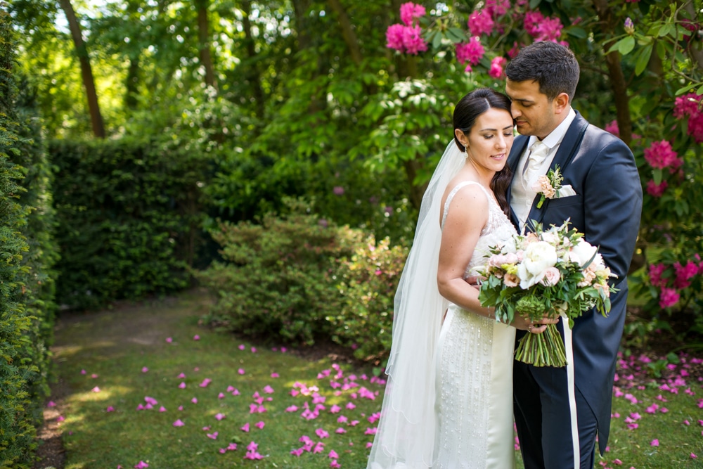 wedding day portrait with pink flowers in background.