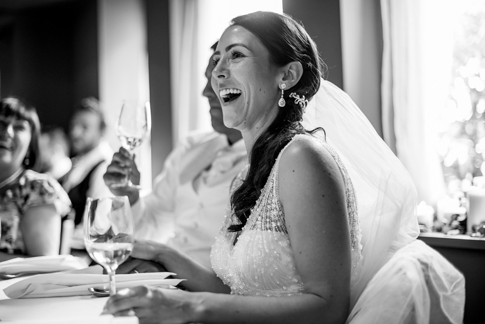 bride laughing during wedding speech