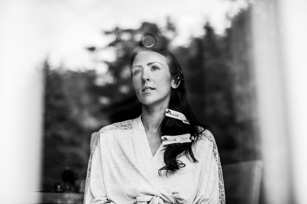 bride looking out window reflecting trees