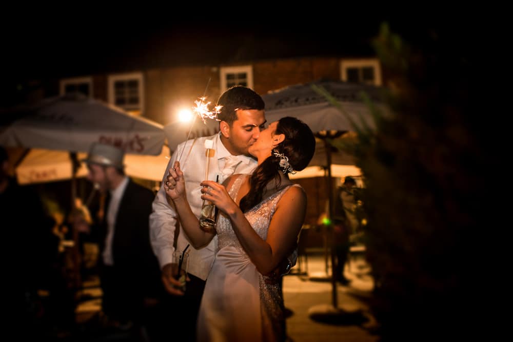 bride and groom kissing with sparkler