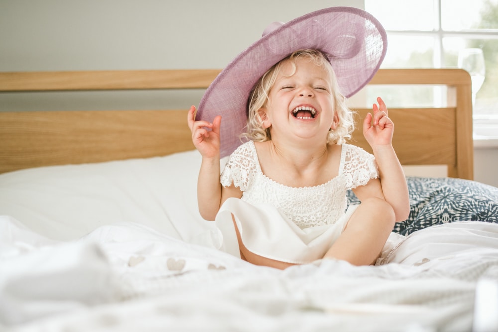 flower girl laughing with large pink hat