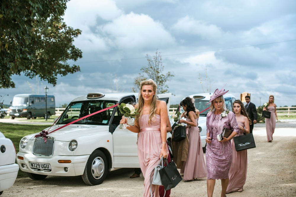 Bridesmaids arriving at Micklefield Hall in white taxis