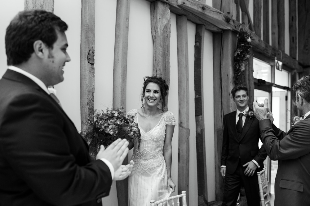 bride and groom walking into barn