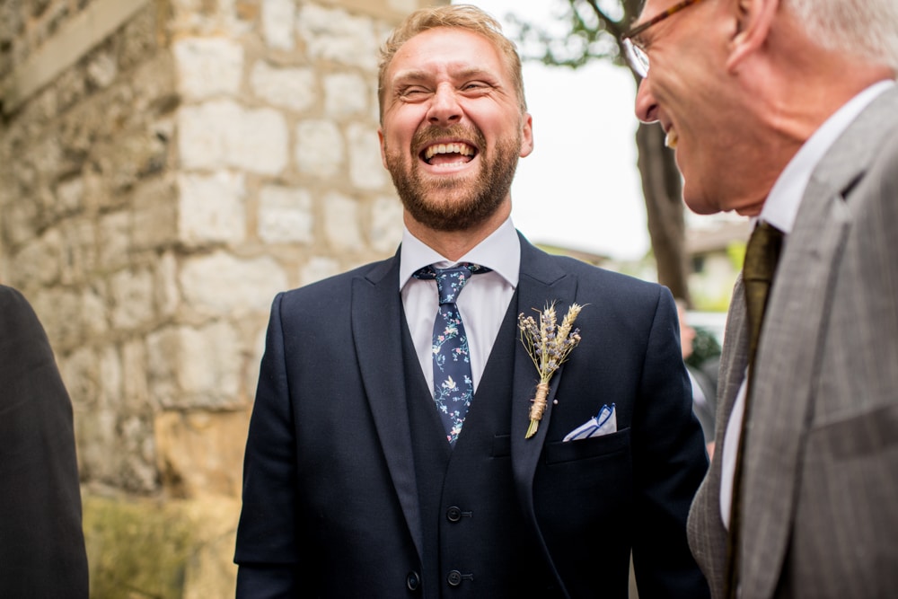 groom laughing outside church