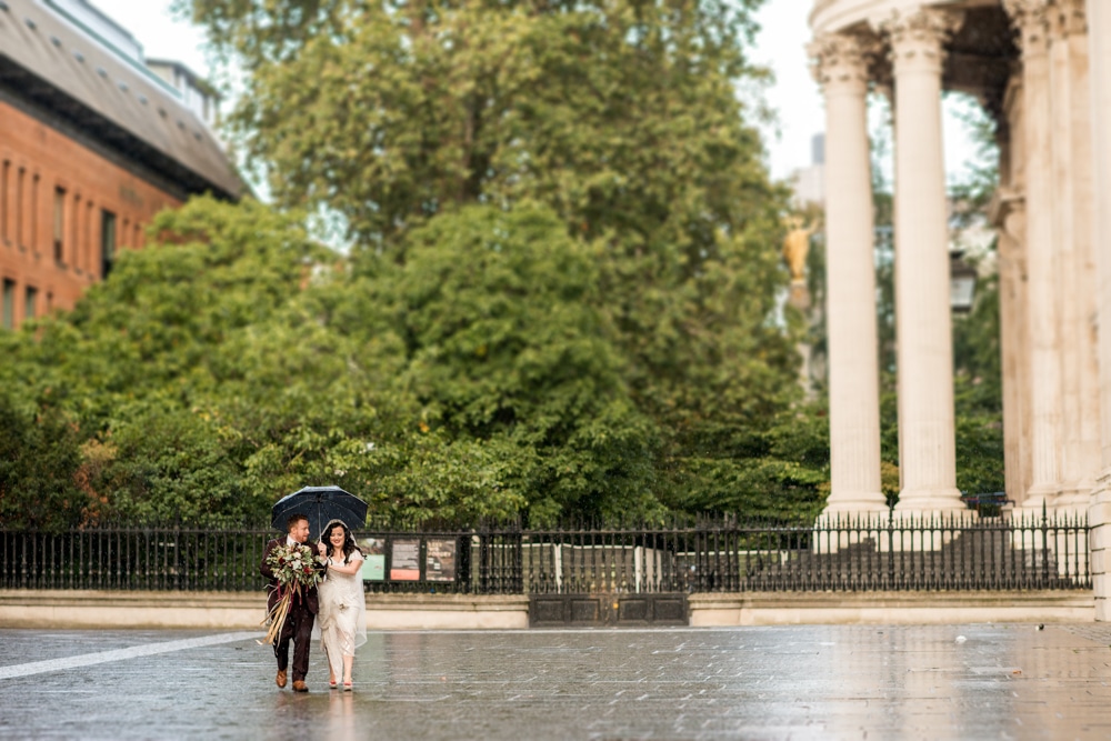 bride and groom walking outside St Pauls