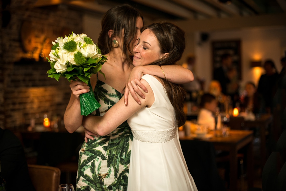 Bride hugging her best friend at wedding