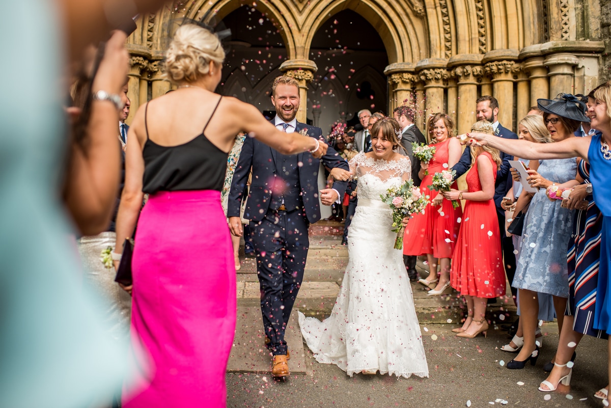 bride and groom exiting church, confetti line