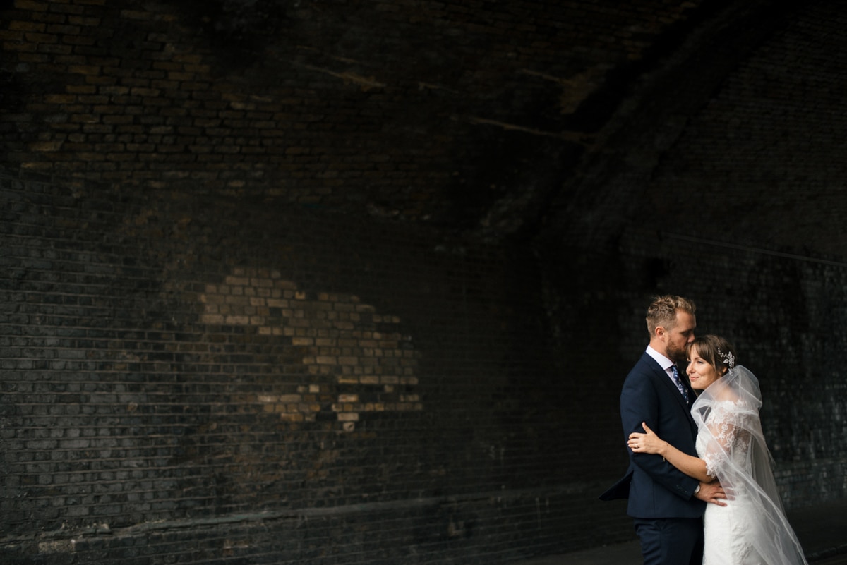 Bride and groom portrait under railway arches, East London Hackney