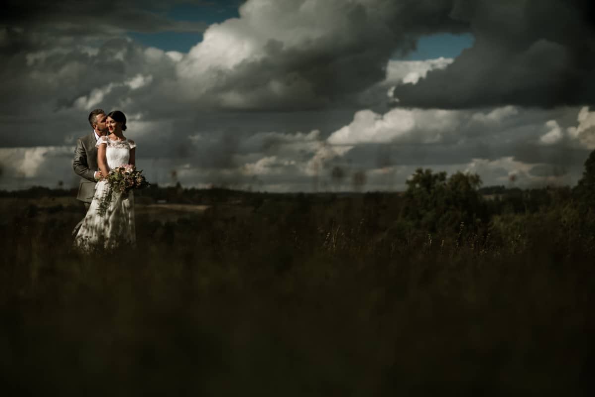 bride and groom portrait in field in France, dramatic light