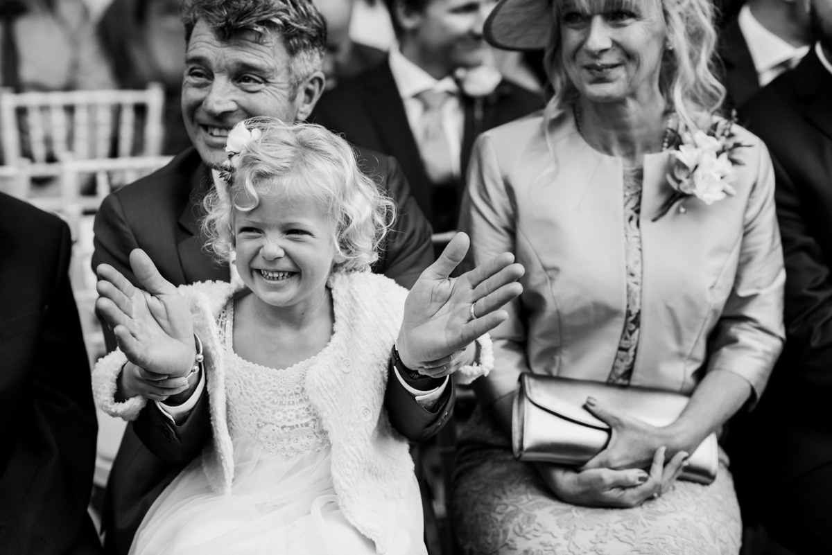 Flower girl clapping with granddad during ceremony