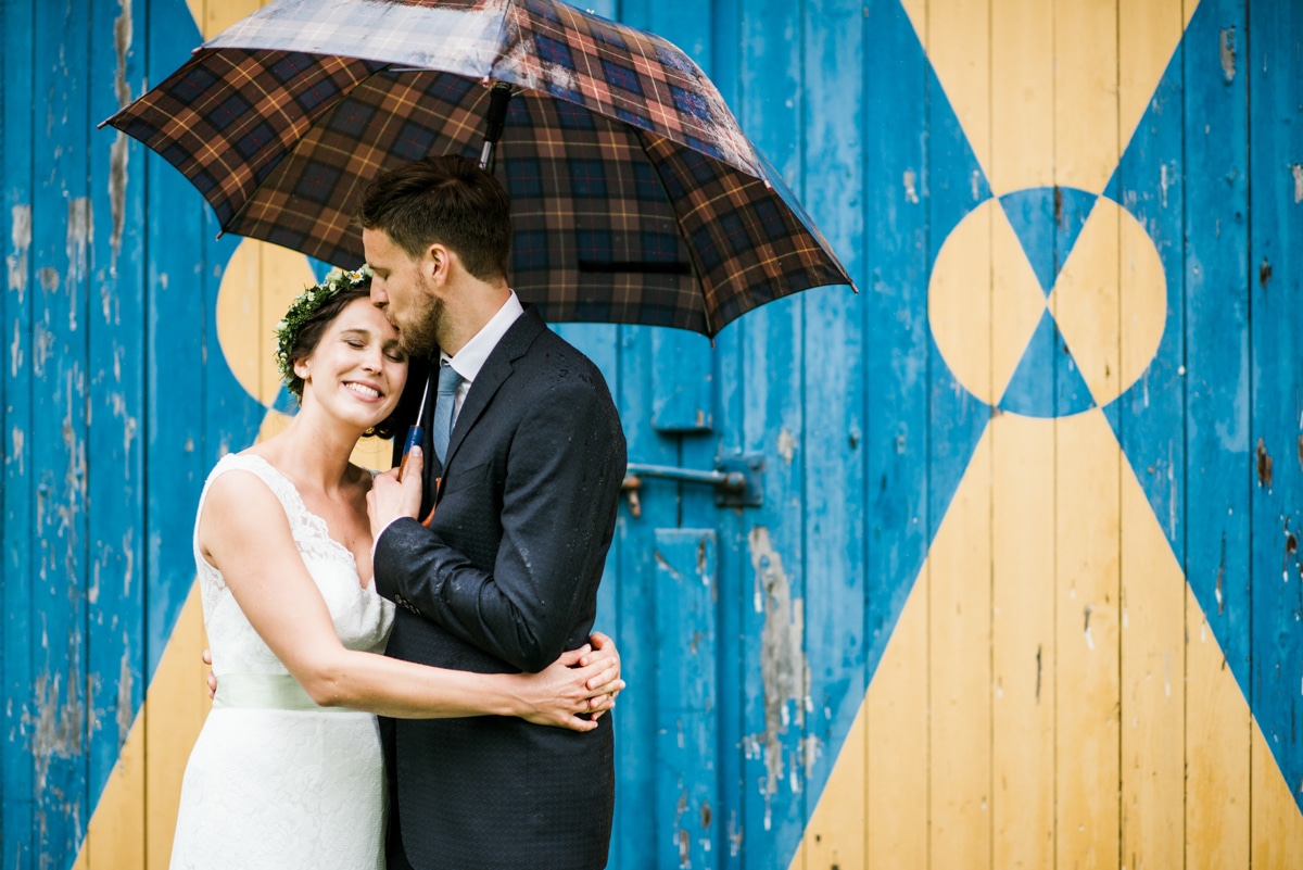 Bride and groom under umbrella