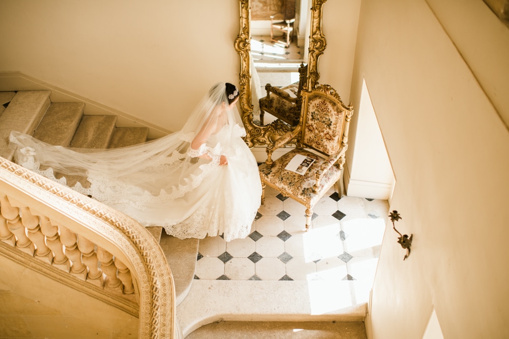 Bride walking down stairs at Chateau De Laurantie