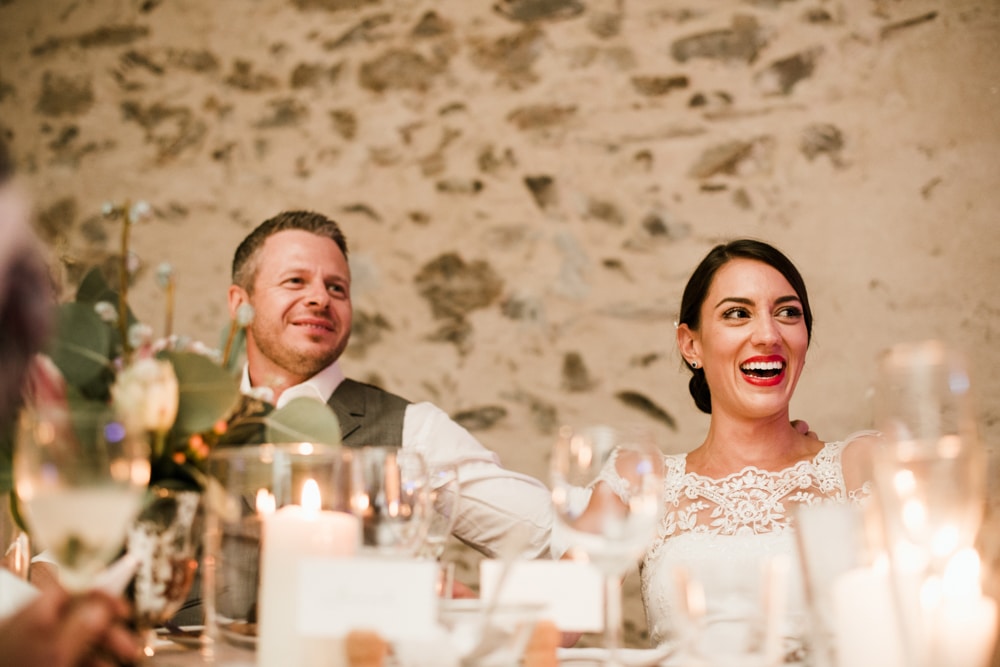 bride and groom smiling during speeches