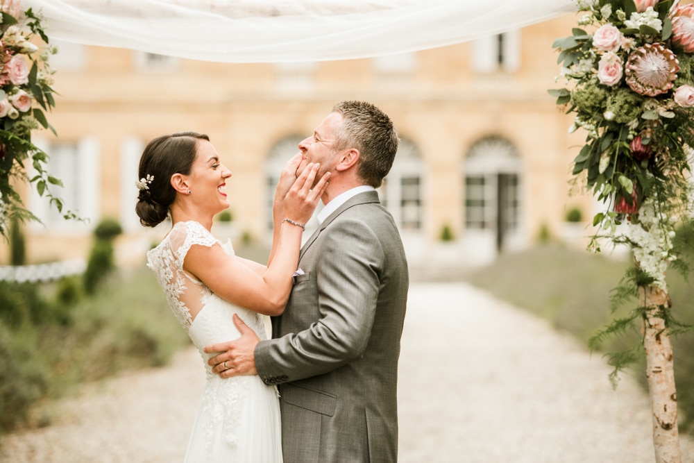 bride wiping lipstick away from grooms lips
