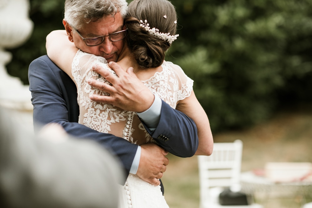 father hugging daughter on wedding day