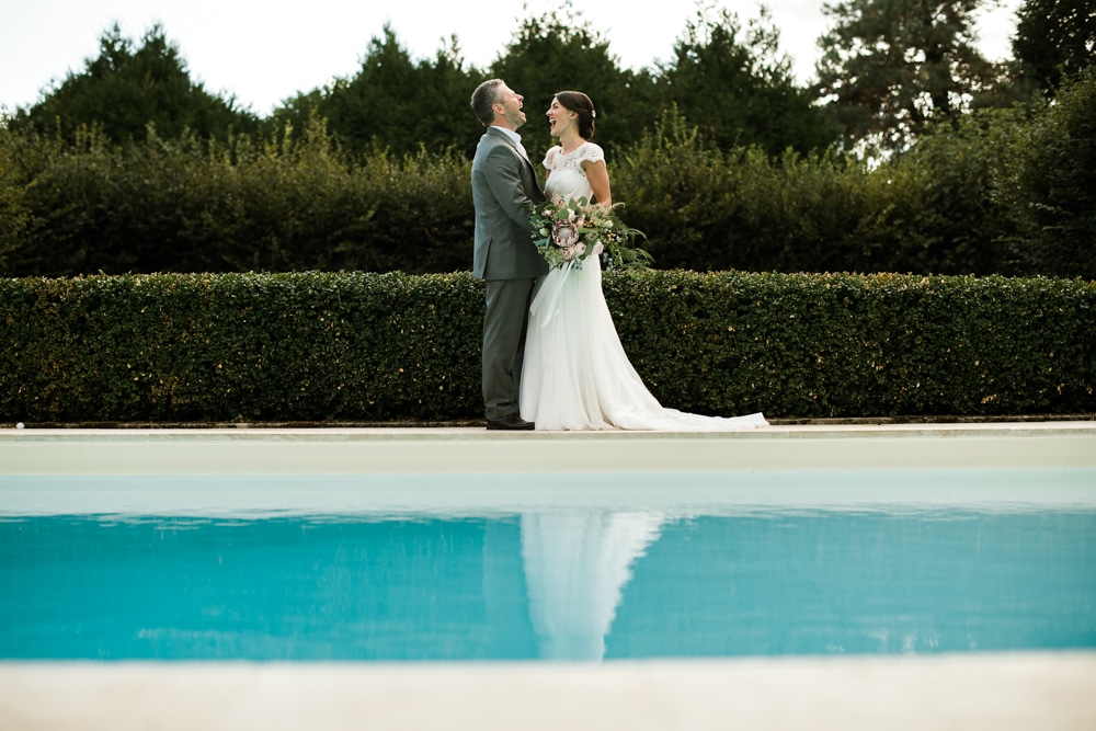 wedding day portraits of bride and groom around swimming pool