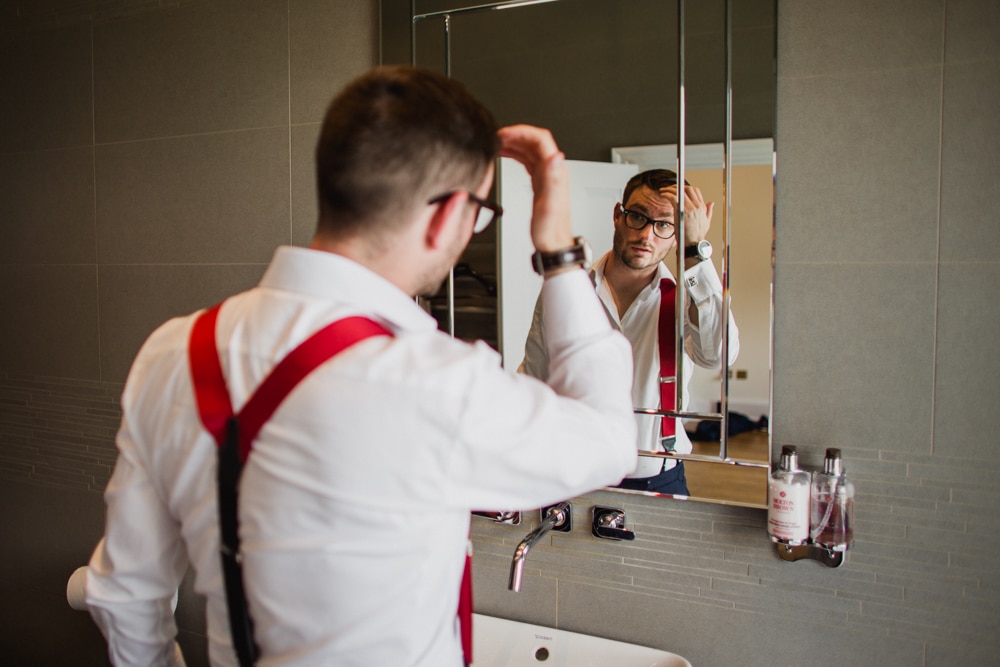 groom getting ready looking at reflection