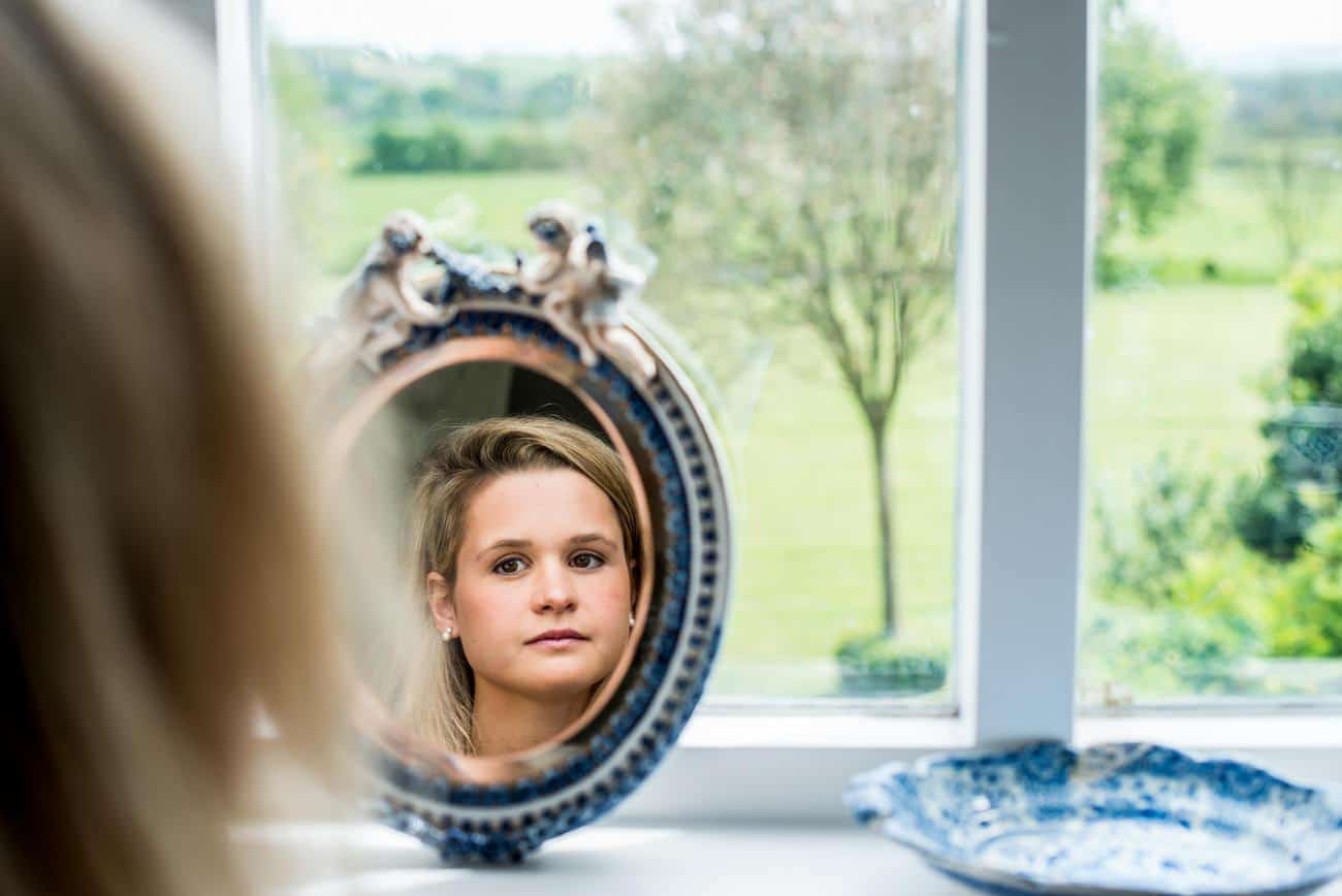 reflection of bride in mirror with countryside in background