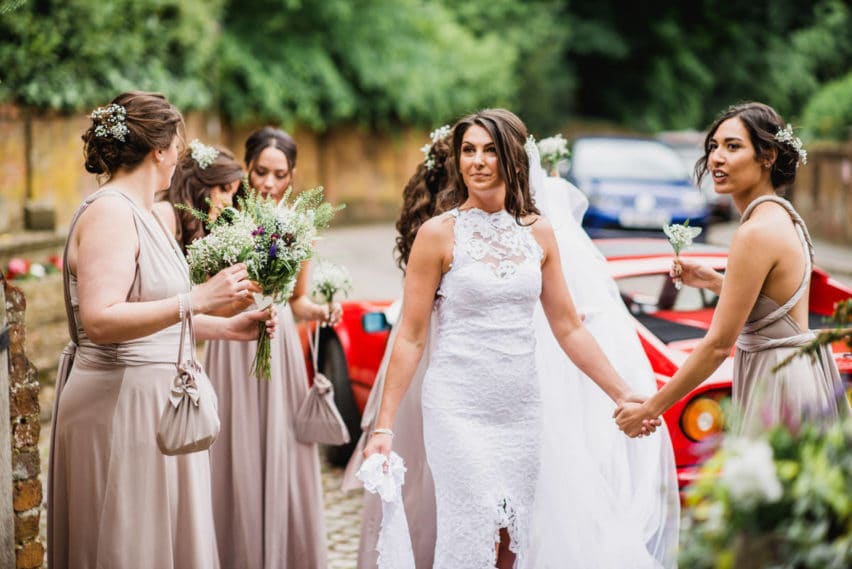 bride holding hands with bridesmaid
