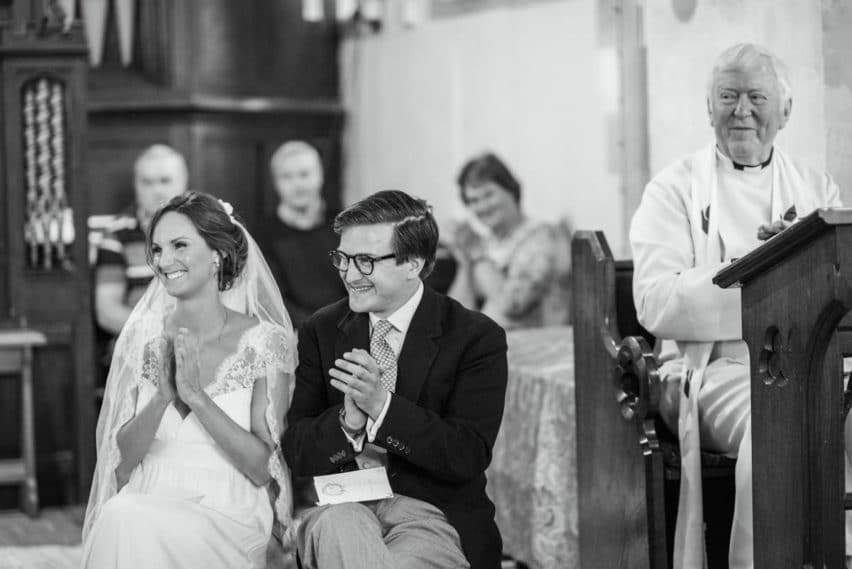 bride and groom clapping in church
