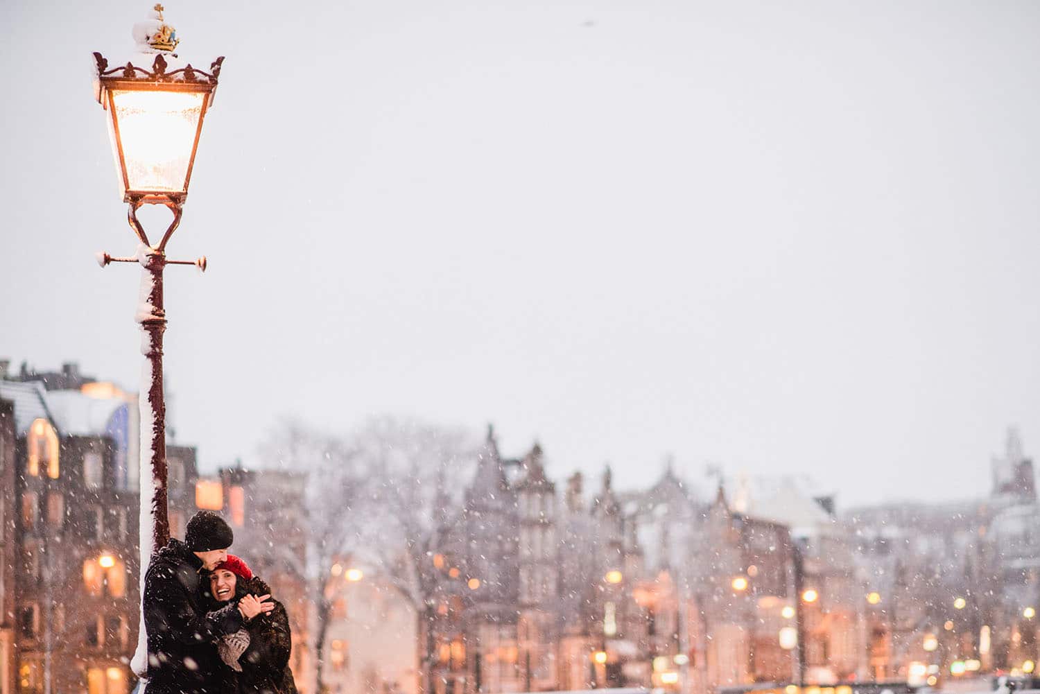 couple embracing under lamppost in snow