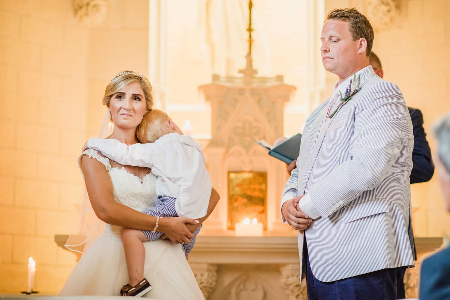 bride holding child during ceremony