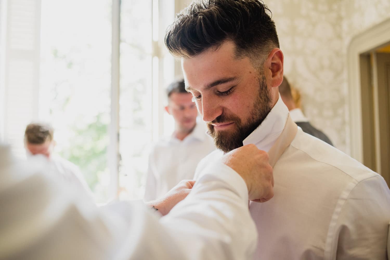 groomsmen putting ties on