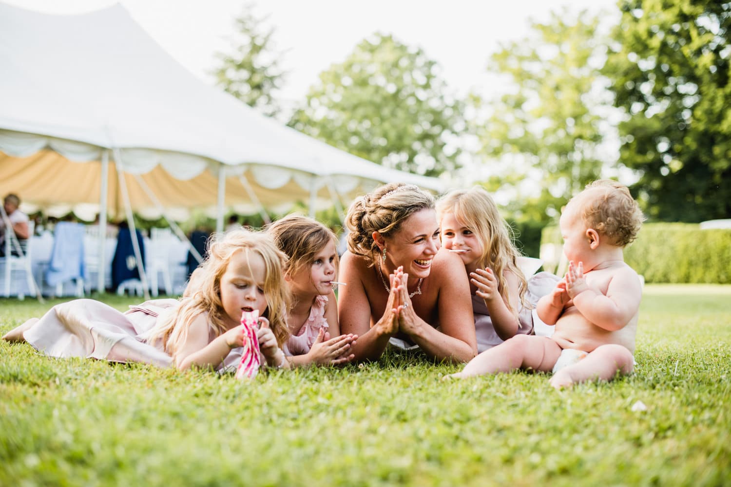 bride laying on grass with kids