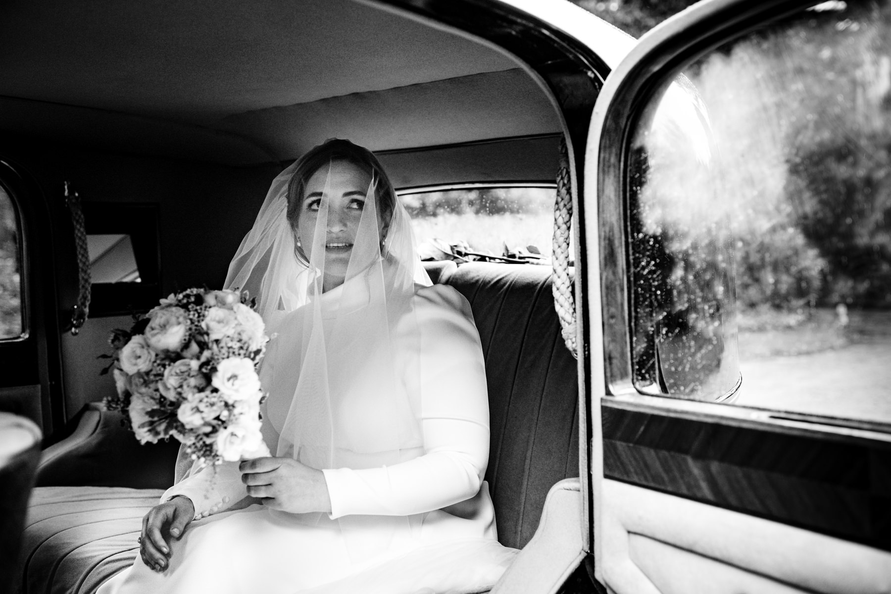 bride in wedding car with misted up windows