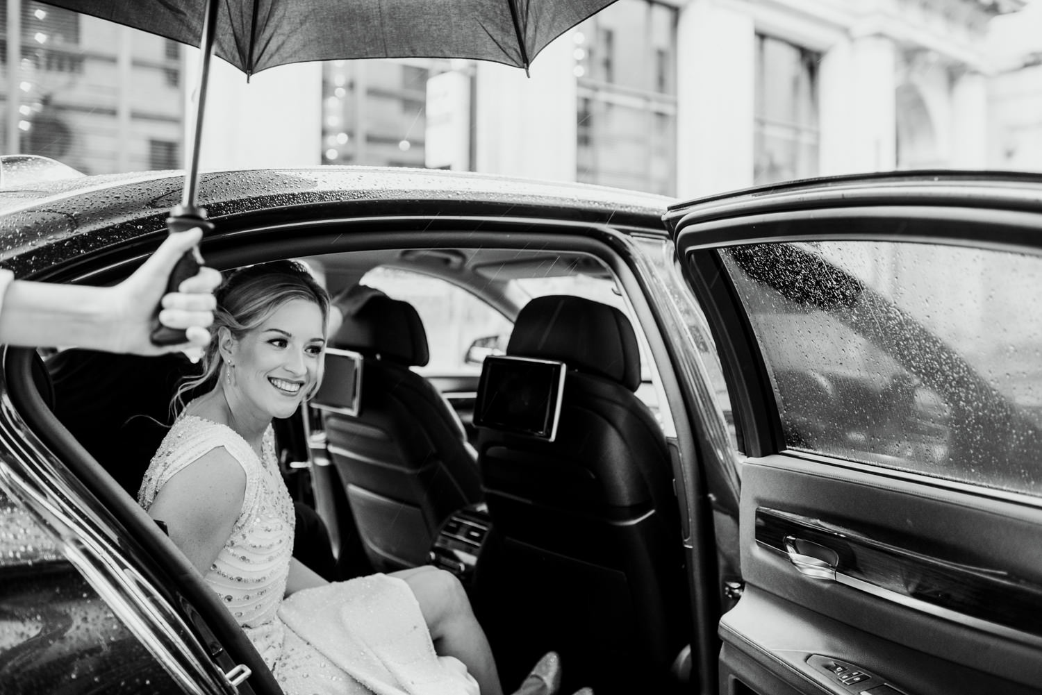 bride getting out of car in rain