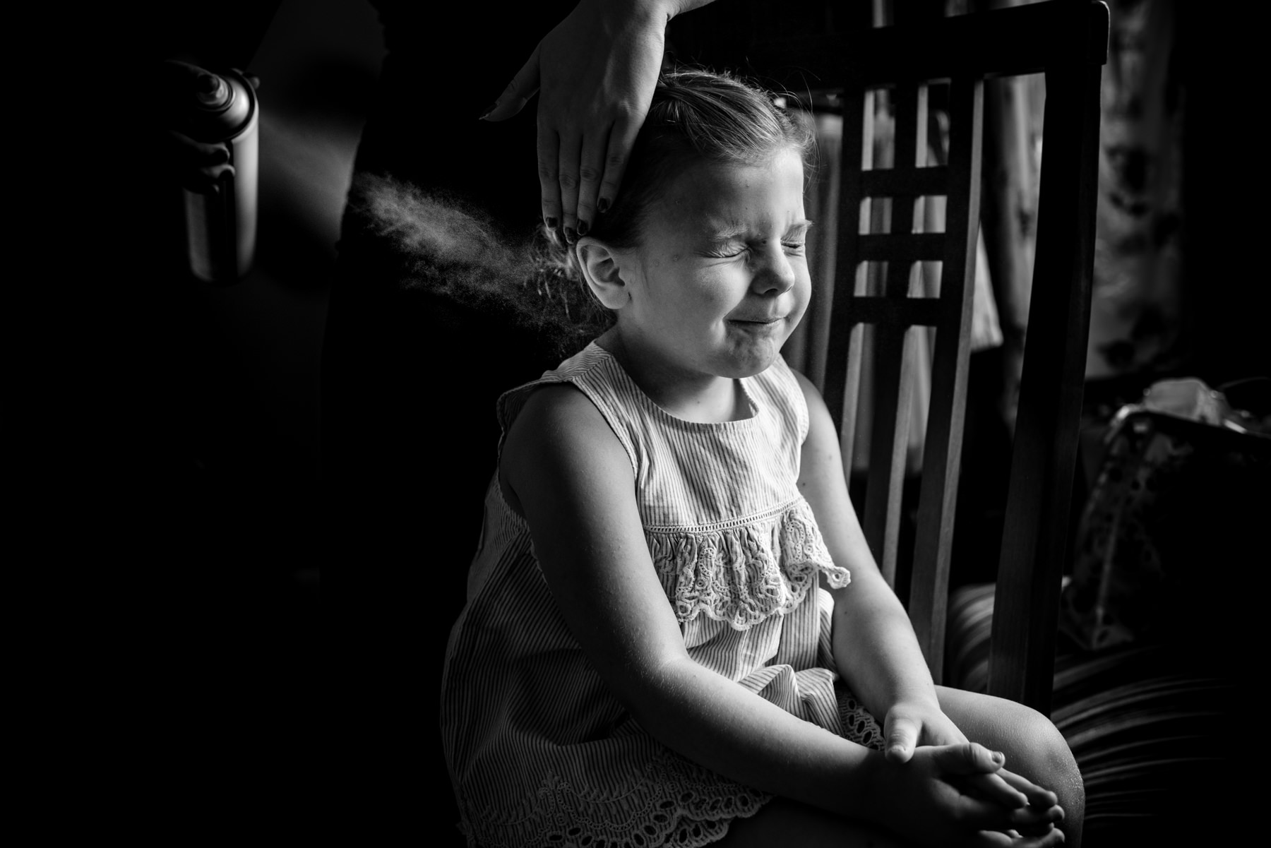 flower girl getting hair sprayed